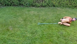 naked pathetic slave during outdoor party, handcuffed, jumps around