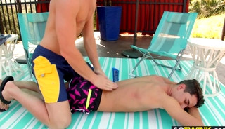 Hunk gay gives a massage to a teen near the pool