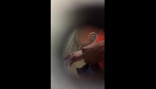 A male is pissing in the toilet.