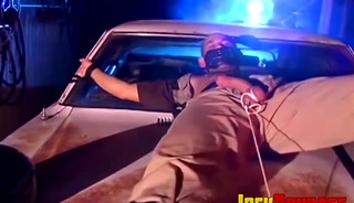 Submissive police officer tied up on the hood of a car