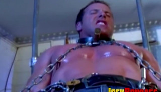 Submissive man struggles while in chains and dominated